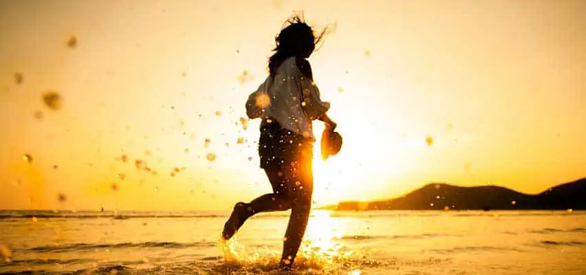 woman running on beach sunset